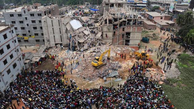 Volunteers and rescue workers seen a day after the Rana Plaza collapse on April 24, 2013 in Savar, on the outskirts of Dhaka. The factory building had been expanded illegally, with additional floors stacked one on top of another. An engineer had declared it unsafe, and the thousands of people who worked inside, stitching garments for clothing brands from around the world, knew it was trouble. (Munir Uz Zaman / AFP File)