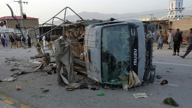 Policemen and locals gather near a destroyed police truck, after three suicide bomb attacks in southwestern city of Quetta, Pakistan April 24. (Reuters Photo)