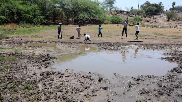 Children play cricket near a dirty wetland at Wagholi on World Earth Day in Pune. World Earth Day was celebrated on April 22, 2018. (Shankar Narayan/HT PHOTO) 