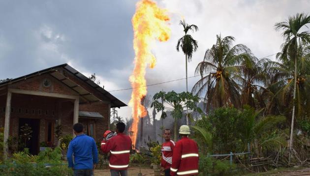 Indonesian fire fighters battle to extinguish a fire at an illegal oil well in Peureulak on April 25, 2018.(AFP)