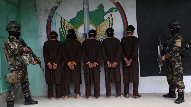 Afghan security forces stand next to Taliban militants as they are to the media in Ghazni province on April 14, 2018. Afghan security forces arrested five Taliban militants during an operation in Ghazni province.(AFP)