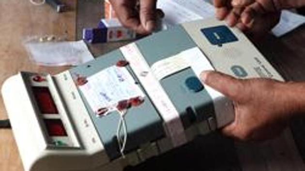 Election Commission officials seal an Electronic Voting Machine at a polling station in Dibrugarh, Assam.(AP File Photo)