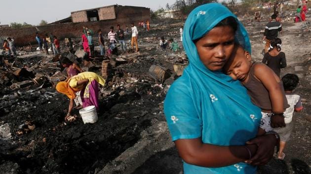 A woman and her daughter (L) rummage through debris for belongings after a fire broke out in a slum in New Delhi on April 24, 2018. (Adnan Abidi / REUTERS) A woman and her daughter (L) rummage through debris for belongings after a fire broke out in a slum in New Delhi on April 24, 2018. (Adnan Abidi / REUTERS)