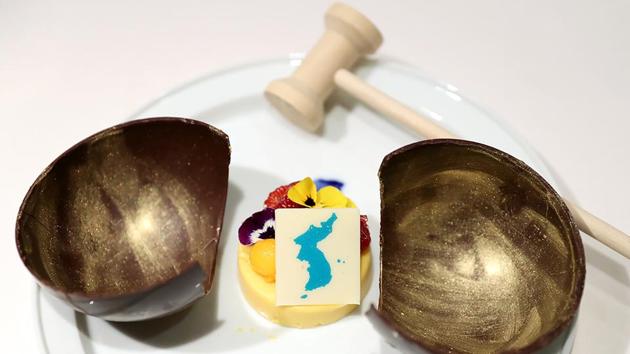 A mango mousse cake decorated with a garnish in the shape of a unified Korean peninsula. The cake is in a wooden bowl, a symbol of Cold War confrontation, which will be broken by a hammer to symbolize the start of reconciliation. The South Koreans will serve Swiss chocolate, macaroons and cheesecake in a set of desserts that Seoul’s presidential Blue House has named “Memories of Swiss.” (The Blue House / AFP)