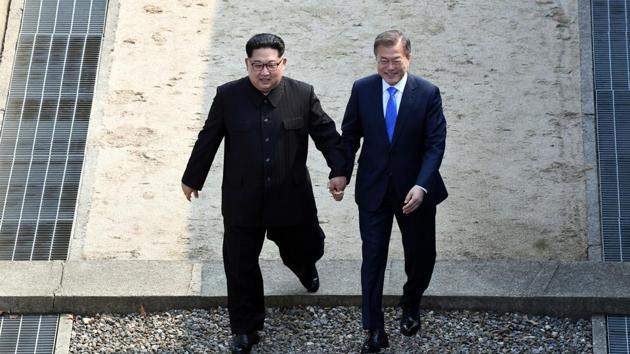 North Korean leader Kim Jong Un, left, and South Korean President Moon Jae-in cross the military demarcation line at the border village of Panmunjom in Demilitarized Zone on Friday, on Friday.(AP Photo)