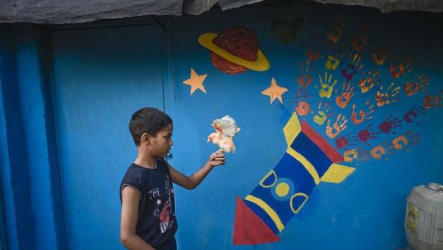 A boy plays with a chick in front of a newly painted wall of the slum. The NGO’s focus is on developing social and emotional competencies within the community, and providing tools necessary for a cohesive, non-violent, and caring community that would ultimately equip them to lead happier and successful lives. (Burhaan Kinu / HT Photo) A boy plays with a chick in front of a newly painted wall of the slum. The NGO’s focus is on developing social and emotional competencies within the community, and providing tools necessary for a cohesive, non-violent, and caring community that would ultimately equip them to lead happier and successful lives. (Burhaan Kinu / HT Photo)