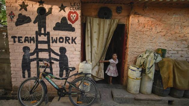 A girl comes out of her house, where the wall depicts art highlighting the importance of teamwork. Art was chosen for its strength as a medium when delivering social cause messages, that runs parallel with the organisation’s community work. (Burhaan Kinu / HT Photo) A girl comes out of her house, where the wall depicts art highlighting the importance of teamwork. Art was chosen for its strength as a medium when delivering social cause messages, that runs parallel with the organisation’s community work. (Burhaan Kinu / HT Photo)