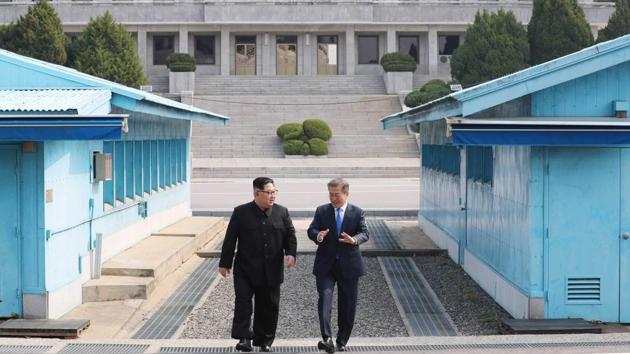 North Korea's leader Kim Jong Un (L) walks with South Korea's President Moon Jae-in (R) after crossing the Military Demarcation Line that divides their countries ahead of their summit at Panmunjom on April 27, 2018.(AFP)