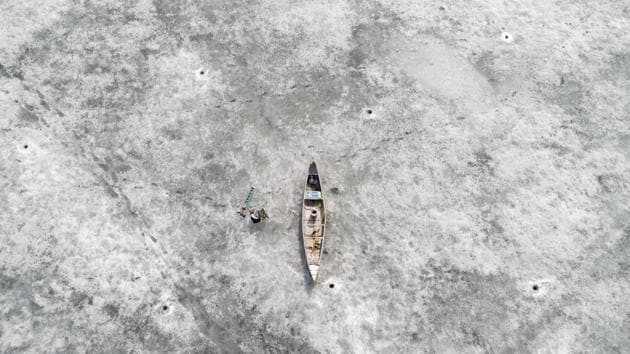 A canoe lies on ice, near holes made by fishermen, on the melting frozen sea, in spite of warm temperatures at the beginning of spring, in Bjoerkoe, Raipaluoto island, western Finland. (Olivier Morin / AFP) A canoe lies on ice, near holes made by fishermen, on the melting frozen sea, in spite of warm temperatures at the beginning of spring, in Bjoerkoe, Raipaluoto island, western Finland. (Olivier Morin / AFP)