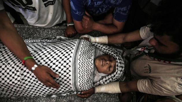 Friends of Palestinian Tahrir Wahaba, 18, mourn over his body during his funeral in Khan Yunis, in the southern Gaza Strip. Wahada died after he was wounded with a shot to the head by Israeli fire in a clash east of Khan Yunis earlier in the month on April 6. (Said Khatib / AFP) Friends of Palestinian Tahrir Wahaba, 18, mourn over his body during his funeral in Khan Yunis, in the southern Gaza Strip. Wahada died after he was wounded with a shot to the head by Israeli fire in a clash east of Khan Yunis earlier in the month on April 6. (Said Khatib / AFP)