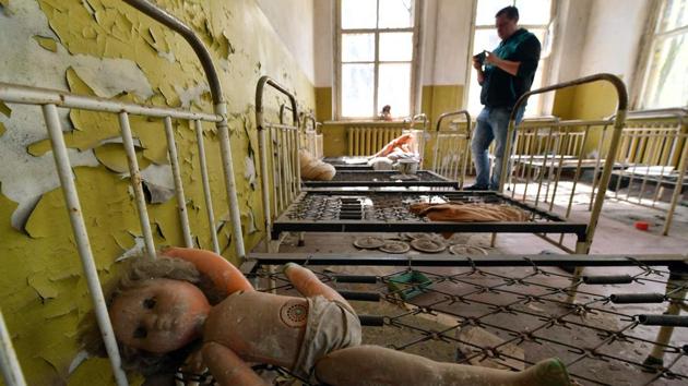 A tourist takes a picture in an abandoned kindergarten in the ghost village of Kopachi near Chernobyl Nuclear power plant during their tour to the Chernobyl exclusion zone. (Sergei Supinsky / AFP) A tourist takes a picture in an abandoned kindergarten in the ghost village of Kopachi near Chernobyl Nuclear power plant during their tour to the Chernobyl exclusion zone. (Sergei Supinsky / AFP)