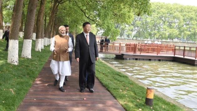 Prime Minister Narendra Modi and Chinese President Xi Jinping walk along the East Lake in Wuhan, China, on Saturday.(Reuters photo)