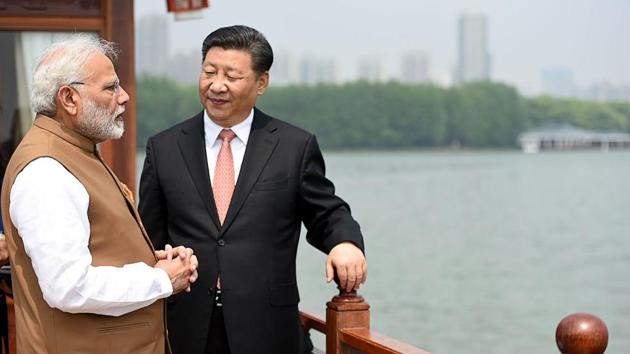 Indian Prime Minister Narendra Modi (L) and Chinese President Xi Jinping looking on in a house boat, at East Lake, in Wuhan.(AFP)