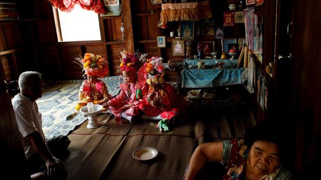 Danusorn Sdisaithaworn (L), Gorsak Kong Tawan  and Phuwadol Kong Tawan have lunch after praying in a house of a relative. The parade takes place the next day, preceding a more contemplative period on the third day, when the boys visit relatives’ homes to pray for their families. (Jorge Silva / REUTERS) 