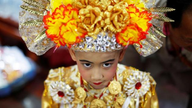 “I like having my head shaved,” said August, a smiling 8-year-old clad in red and gold, with an ornate hat that featured flowers and diamante trim, as he described his favourite part of the rite. (Jorge Silva / REUTERS) 