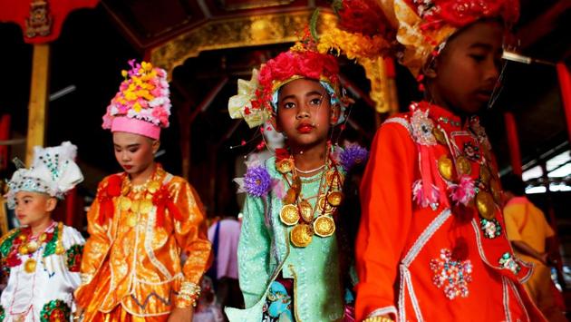 Dressed in clothes dominated by neon pinks and greens with elaborate headgear, their lips and cheeks brightly rouged for the most important day of their short lives, about 50 boys advanced to the lively beat of drums, cymbals and gongs. (Jorge Silva / REUTERS) 