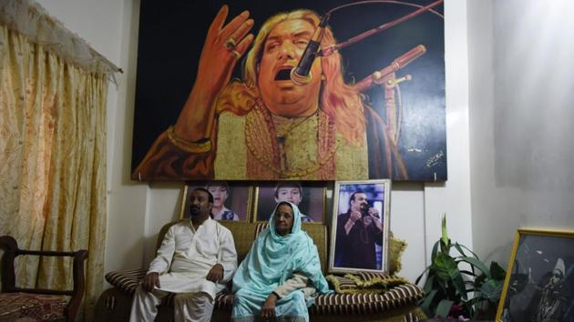Talha Sabri is flanked by his mother, an image of his father Qawwal Ghulam Farid Sabri overhead. “Regardless of these threats, we have to keep on,” he said. For Sabri’s mother Asghari Begum however, the murder of her son marked a turning point for qawwali, ringing the death knell for its future. “He has gone now,” she said. “And the passion of qawwali has gone with him.” (Rizwan Tabassum / AFP) 