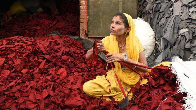 A woman shreds clothes with special slicers. The shredded woollen scrap is turned back into a yarn called shoddy. The piles of clothes have already been sorted into the basic colour families of gray, red, blue, camel and green --winter clothing colours in the West. Shoddy blankets are rough, coarse and usually brown or grey but the Chinese blankets are light, soft and come in a variety of colours. (Vipin Kumar / HT Photo) 