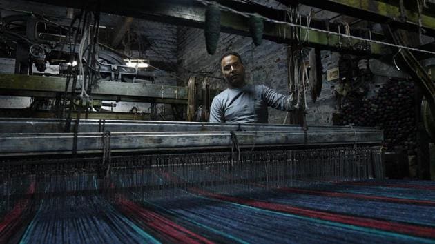 Explaining the process of making these blankets, Surender Gupta, owner of Shankar Woollen Mill said, once the zips, buttons and linings are ripped, the shredded clothes are put into rag-pulling machines. Uniformly coloured fluff emerges from that and then the fluff is soaked in oil for conditioning and re-conditioning, after which it is pulled apart in a carding machine and finally twisted into yarn. (Vipin Kumar / HT Photo) 