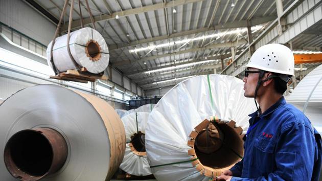 This picture taken on April 19, 2018 shows a worker transferring rolls of aluminum at a factory in Zouping in China's eastern Shandong province. / AFP PHOTO / - / China OUT (AFP Photo) This picture taken on April 19, 2018 shows a worker transferring rolls of aluminum at a factory in Zouping in China's eastern Shandong province. / AFP PHOTO / - / China OUT (AFP Photo)