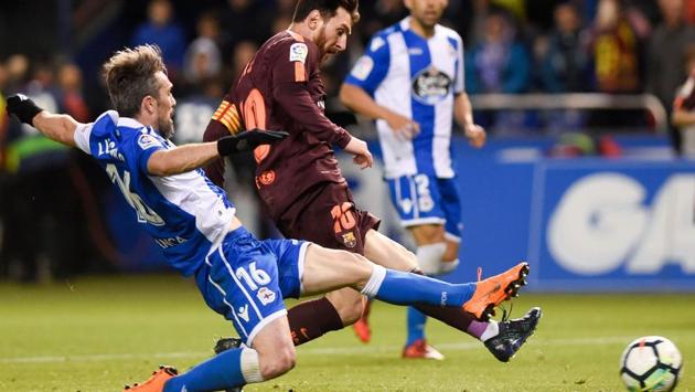 FC Barcelona'Lionel Messi slips the ball past Deportivo La Coruna defender Luisinho (L) during their La Liga match on Sunday. (AFP) FC Barcelona'Lionel Messi slips the ball past Deportivo La Coruna defender Luisinho (L) during their La Liga match on Sunday. (AFP)