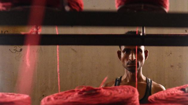 A worker seen in a thread making unit for shoddy blankets. The factories not shifting to Chinese fleece are trying to survive by diversifying into cotton yarn. Garg’s own factory, Swastika Spinning Mills, has also diversified into cotton yarns. He says, the shoddy yarn industry has lost its sheen. “There are now about 50 cotton yarn units in Panipat. They started coming up 10 years ago,” Garg said. (Vipin Kumar / HT Photo) 