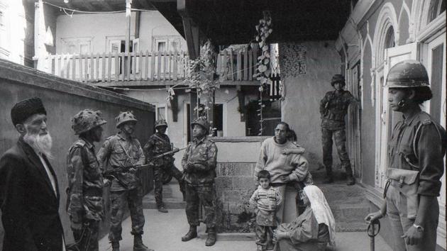 A family in Alikadal, Srinagar, waits while their home is searched by the Indian Army, 1993. Meraj-ud-din shot the photo of Yusuf Shah (Syed Salahuddin) campaigning in 1987 in a shroud. A later image of Yasin Malik, flamed protests against Meraj in Jammu and saw his home ransacked. He has been beaten 11 times by security forces in the course of his work. After the eleventh beating, Meraj stopped counting. (Courtesy Meraj-ud-din) A family in Alikadal, Srinagar, waits while their home is searched by the Indian Army, 1993. Meraj-ud-din shot the photo of Yusuf Shah (Syed Salahuddin) campaigning in 1987 in a shroud. A later image of Yasin Malik, flamed protests against Meraj in Jammu and saw his home ransacked. He has been beaten 11 times by security forces in the course of his work. After the eleventh beating, Meraj stopped counting. (Courtesy Meraj-ud-din)