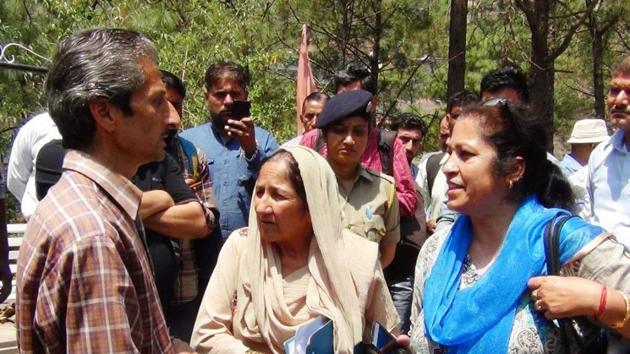Hotel owner owner Vijay Singh (left), who is now absconding, and assistant town planner Shail Bala Sharma (right) during the demolition drive in Kasauli on Tuesday. Singh allegedly shot her dead minutes later.(HT Photo)