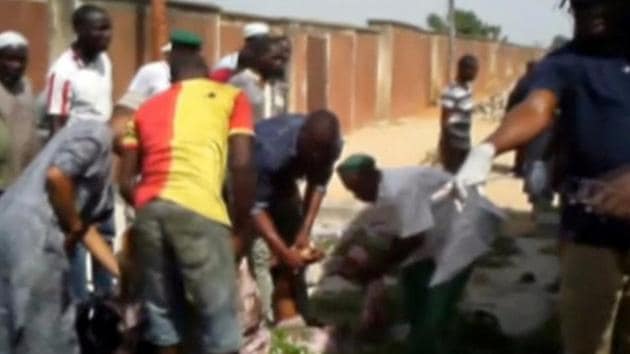 A still image taken from a video shot shows people helping an injured at the site of a blast attack in Mubi, Nigeria. (Reuters) A still image taken from a video shot shows people helping an injured at the site of a blast attack in Mubi, Nigeria. (Reuters)