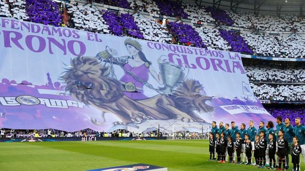 Real Madrid players line up before the match against Bayern Munich as fans display a banner at Santiago Bernabeu. (REUTERS) Real Madrid players line up before the match against Bayern Munich as fans display a banner at Santiago Bernabeu. (REUTERS)