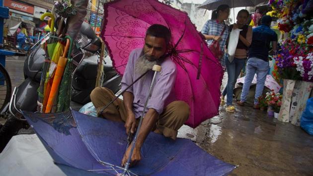 A mechanic repairs an umbrella during rain in Guwahati on Wednesday in Assam. (Anupam Nath / AP) A mechanic repairs an umbrella during rain in Guwahati on Wednesday in Assam. (Anupam Nath / AP)