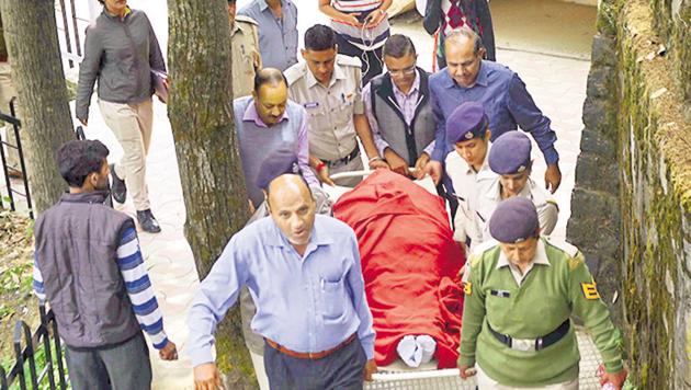 Police carry the body of assistant town planning officer Shail Bala Sharma for a post-mortem examination at the IGMC hospital in Shimla on Wednesday.(PTI Photo)