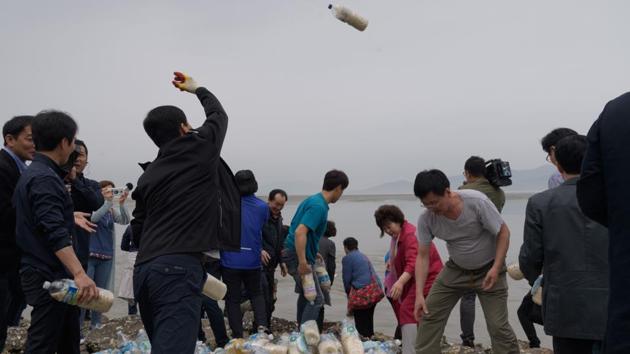 North Korean defectors sent water bottles filled with rice and K-pop-loaded USB sticks floating towards their homeland Tuesday, even as the two Koreas removed border loudspeakers following a rare summit last week. The North’s leader Kim Jong Un and the South’s president Moon Jae-in agreed last week to “completely cease all hostile acts” along the Demilitarized Zone from May 1, including loudspeaker broadcasts and leaflet balloon launches. (Ed Jones / AFP) 