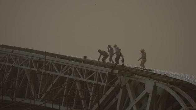 Labourers seen working at Noida stadium as the dust storm enveloped the city. The storm, with wind speed exceeding 45 kmph, hit Chandigarh during the afternoon, forcing vehicles to move with their headlights on as visibility reduced considerably. (Virendra Singh Gosain / HT Photo) Labourers seen working at Noida stadium as the dust storm enveloped the city. The storm, with wind speed exceeding 45 kmph, hit Chandigarh during the afternoon, forcing vehicles to move with their headlights on as visibility reduced considerably. (Virendra Singh Gosain / HT Photo)