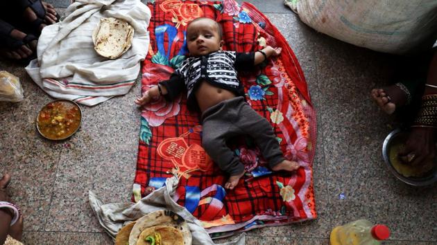 A child lies on a bed sheet as the family eats food at a railway station in New Delhi on May 1, 2018. (Saumya Khandelwal / REUTERS) A child lies on a bed sheet as the family eats food at a railway station in New Delhi on May 1, 2018. (Saumya Khandelwal / REUTERS)