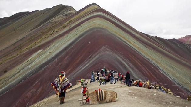 An Andean man and his IIama rest on mountain formed of stripes of turquoise, lavender and gold known as “Rainbow Mountain.” This ridge of multicoloured sediments laid down millions of years ago was pushed up as tectonic plates clashed. Just five years into its discovery by the outside world, Rainbow Mountain has earned a must-see status on Peru’s burgeoning backpacker circuit. (Martin Mejia / AP) An Andean man and his IIama rest on mountain formed of stripes of turquoise, lavender and gold known as “Rainbow Mountain.” This ridge of multicoloured sediments laid down millions of years ago was pushed up as tectonic plates clashed. Just five years into its discovery by the outside world, Rainbow Mountain has earned a must-see status on Peru’s burgeoning backpacker circuit. (Martin Mejia / AP)