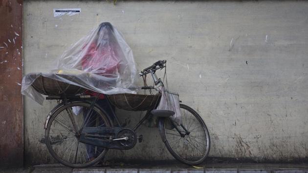 A fruit vendor stands covered in plastic to protect himself from rain in Guwahati, Assam on May 2, 2018. (Anupam Nath / AP) A fruit vendor stands covered in plastic to protect himself from rain in Guwahati, Assam on May 2, 2018. (Anupam Nath / AP)