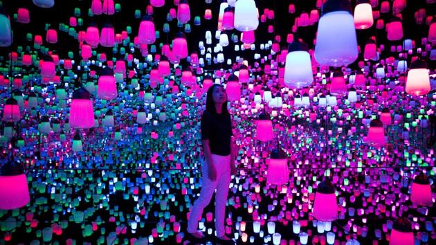 A Japanese member of Teamlab collective walks and poses in a digital installation room with hanging lamps, that illuminate as the visitor nears, at Mori Building Digital Art Museum in Tokyo, Japan. (Behrouz Mehri / AFP) A Japanese member of Teamlab collective walks and poses in a digital installation room with hanging lamps, that illuminate as the visitor nears, at Mori Building Digital Art Museum in Tokyo, Japan. (Behrouz Mehri / AFP)