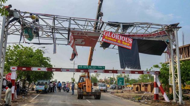 Authorities salvage a hoarding, damaged in Wednesday night's massive storm, near Bharatpur district of Rajasthan.(PTI)