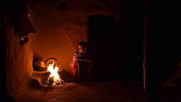 A woman cooks food by fire, the only light inside her home in Kraska village. The government has been trying to relocate Kraska and other villages under the CTH area in order to create an inviolate region free from human presence that can allow the reintroduction of tigers in Sariska for a number of years now. (Anindito Mukherjee / Bloomberg)