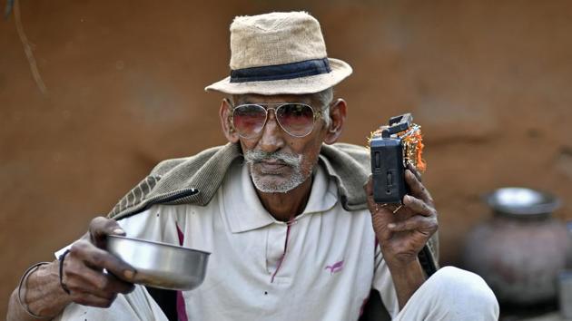 A man listens to a battery powered radio at a home in Kraska village. Some families don’t want to leave their homes and others are sticking it out in hope of a better deal. Authorities don’t intend to provide or maintain utility services to these areas. (Anindito Mukherjee / Bloomberg)
