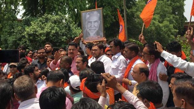 Hindu Jagran Manch activists hold a portrait of Raja Mahendra Pratap Singh, demanding its installation at AMU in Aligarh on Sunday.(HT PHOTO)