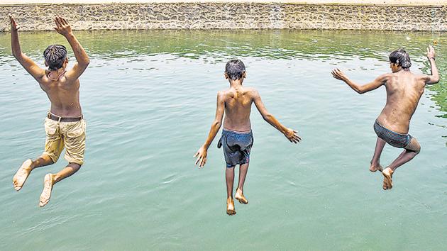 Children jump into a canal near Janta Vasahat to escape the scorching heat.(SANKET WANKHADE/ HT PHOTO)