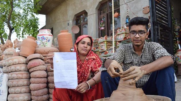 Sheela Devi displays a copy of the MC notice at Potters Colony, Maloya, in Chandigarh, on Friday.(Sikander Singh Chopra/HT)