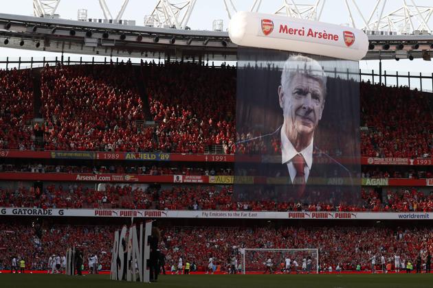 A large photograph of Arsenal's French manager Arsene Wenger is suspended from the roof as players take a lap of honour on the pitch. (AFP) A large photograph of Arsenal's French manager Arsene Wenger is suspended from the roof as players take a lap of honour on the pitch. (AFP)