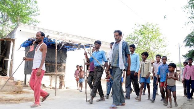 Villagers hold sticks for protection, at Budhanapur village in Sitapur.(Dheeraj Dhawan/HT File Photo)