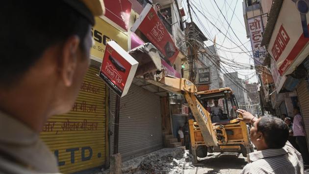 South Delhi Municipal Corporation (SDMC) officials demolish encroachments during an anti-encroachment drive at a market in Kotla Mubarakpur in New Delhi on Tuesday. (Burhaan Kinu / HT Photo)