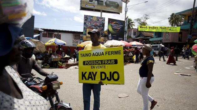Taino Aqua Fish worker Bernard Pierre Emil advertises that their tilapia fish can be bought at a stall outside the Kay Djo supermarket in Petion-Ville, Haiti. Taino markets its crop, which can reach 20,000 pounds a week, to small, informal markets as well as supermarkets, hotels and restaurants. (Dieu Nalio Chery /AP) Taino Aqua Fish worker Bernard Pierre Emil advertises that their tilapia fish can be bought at a stall outside the Kay Djo supermarket in Petion-Ville, Haiti. Taino markets its crop, which can reach 20,000 pounds a week, to small, informal markets as well as supermarkets, hotels and restaurants. (Dieu Nalio Chery /AP)