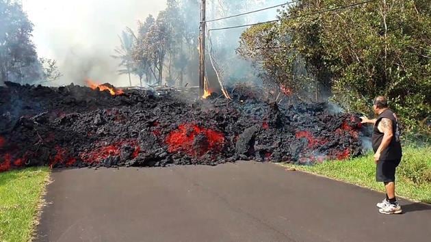 In this photo taken from video an unidentified man gets close to a lava flow advancing down a road in the Leilani Estates subdivision near Pahoa on the island of Hawaii Monday, May 7, 2018. (AP Photo) In this photo taken from video an unidentified man gets close to a lava flow advancing down a road in the Leilani Estates subdivision near Pahoa on the island of Hawaii Monday, May 7, 2018. (AP Photo)