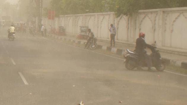 Commuters stop by the side of a road as dust storm lashes Jaipur on Tuesday. Another storm on may 2 had left 35 people dead and 209 injured in the state.(HT Photo)